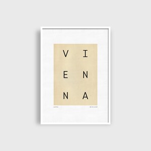 May include: A white framed print with a beige background and the word "VIENNA" spelled out in black letters.