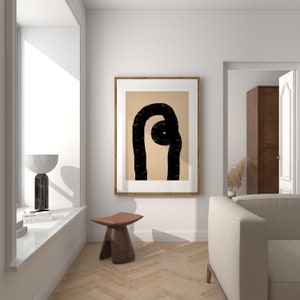 Könnte beinhalten: Ein gerahmter abstrakter Kunstdruck mit einem schwarz-weißen Design auf beigefarbenem Hintergrund. Der Druck hängt an einer weißen Wand in einem modernen Wohnzimmer mit einem Holzhocker und einer Couch.
