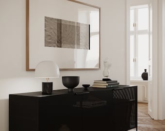 May include: A black metal cabinet with a grid pattern on the doors. The cabinet has two doors and two shelves. There is a lamp, a bowl, and books on top of the cabinet.