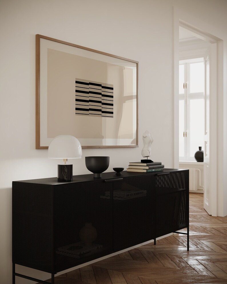 May include: A black metal cabinet with a grid pattern on the doors. The cabinet has two doors and two shelves. There is a lamp, a bowl, and books on top of the cabinet.