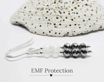 May include: Silver earrings with clear and black beads. The earrings are labeled "EMF Protection".