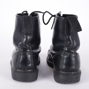 May include: A pair of black leather ankle boots with laces and a thick sole.