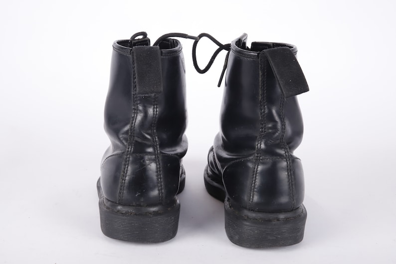 May include: A pair of black leather ankle boots with laces and a thick sole.