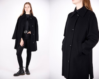 May include: A black long-sleeved coat with a collar and button closure. The coat has a straight fit and is made of a soft, warm fabric.