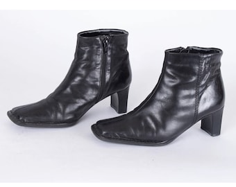 May include: A pair of black leather ankle boots with a square toe and a block heel.