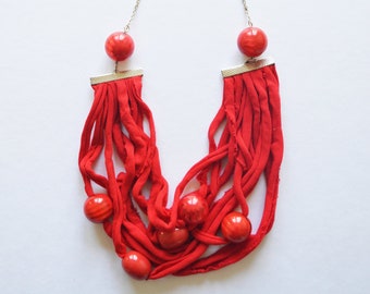 Unique recycled bright red fabric necklace. Handmade from used clothing with striking plastic beads and silver plated chain