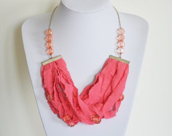 Unique recycled pink fabric necklace. Handmade from used clothing with shimmering plastic beads and silver plated chain