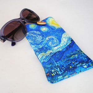 May include: A blue and yellow patterned sunglasses case with a button closure. The case features a painting reminiscent of Vincent van Gogh's "Starry Night".