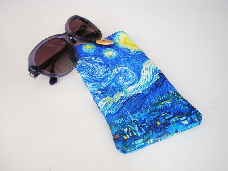 May include: A blue and yellow patterned sunglasses case with a button closure. The case features a painting reminiscent of Vincent van Gogh's "Starry Night".