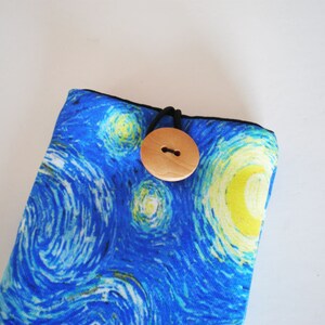 May include: A blue and yellow fabric pouch with a wooden button closure. The fabric features a swirling pattern reminiscent of Van Gogh's Starry Night.