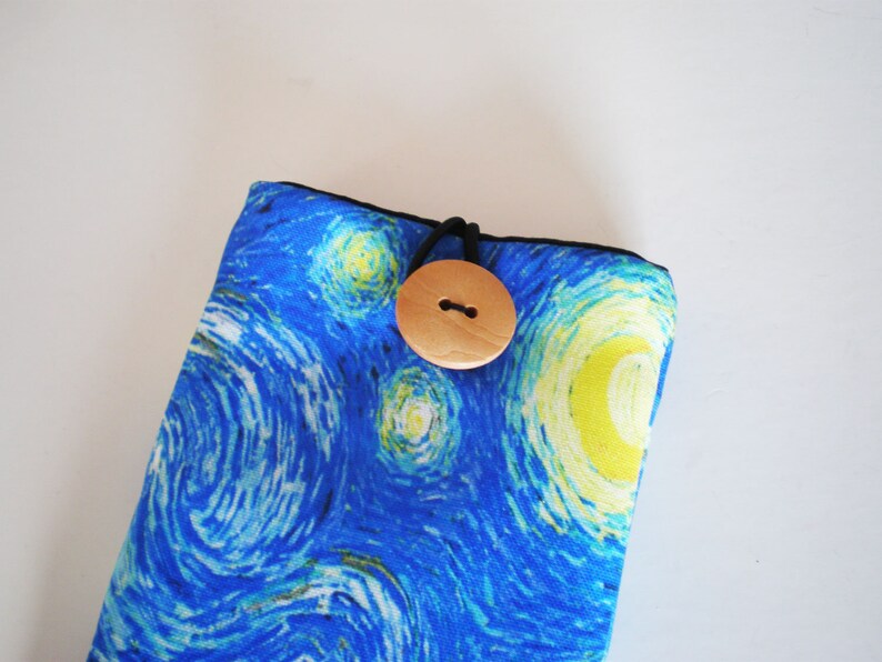 May include: A blue and yellow fabric pouch with a wooden button closure. The fabric features a swirling pattern reminiscent of Van Gogh's Starry Night.