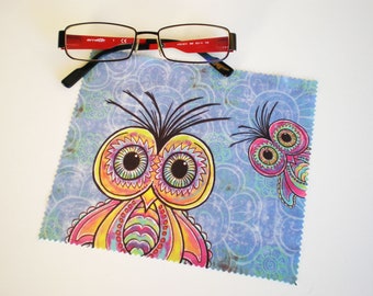 May include: A blue microfiber cleaning cloth with a colorful owl design. The owl has large eyes, a yellow beak, and pink, purple, and green feathers.