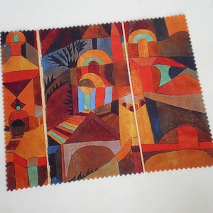 May include: A fabric swatch featuring an abstract geometric design with warm colors. The artwork includes shapes of buildings, arches, and trees in shades of orange, red, brown, and blue. The edges of the fabric are scalloped.