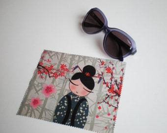 May include: A gray and white microfiber cleaning cloth with a Japanese-inspired design featuring a cartoon woman with black hair and a red flower in her hair. The cloth has a pink and red floral pattern and the text "YODA" is printed on the cloth.