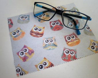 May include: A gray microfiber cleaning cloth with a colorful owl pattern. The cloth is designed to clean glasses and other delicate surfaces.
