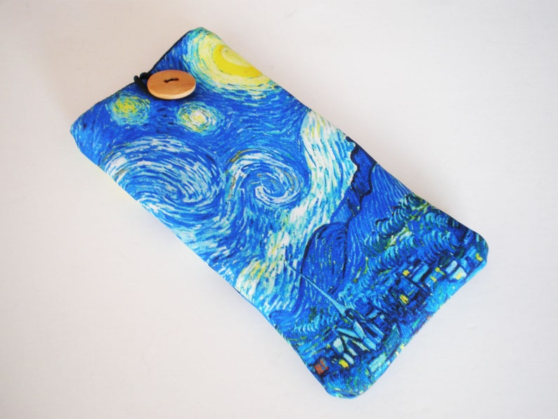 May include: A blue and yellow fabric eyeglass case with a wooden button closure. The case features a print of Vincent van Gogh's "The Starry Night" painting.