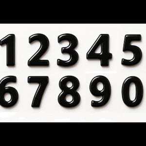 May include: A set of ten glossy black numbers, from 0 to 9, arranged in two rows on a white background. The numbers have a rounded, three-dimensional appearance, suitable for crafts or educational projects.