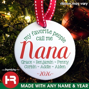 May include: White round Christmas ornament with the text "my favorite people call me Nana" in green and red. Includes names and the year 2026. A red and white ribbon is attached for hanging.
