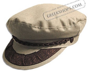 May include: Tan-colored Greek fisherman's cap with a dark brown braided band and a decorative brim. The brim features a detailed leaf pattern. The cap has a button detail on the side and is made of a sturdy fabric.