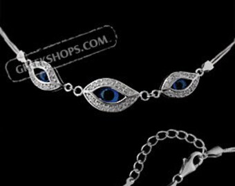 Pode incluir: Pulseira de prata com três pingentes de olho turco azul, cada um adornado com uma fileira de pedras de zircônia cúbica transparentes ao redor do olho. A pulseira tem um fecho de lagosta.