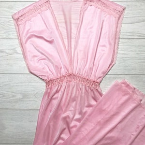 May include: A pink sleeveless maxi dress with a lace trim around the neckline and a gathered waist.