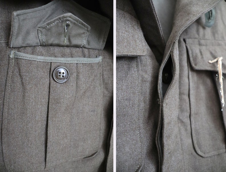 Pu&ograve; includere: Primo piano di una giacca militare verde oliva. La giacca presenta una chiusura con bottoni, due tasche sul petto e una piccola tasca sulla manica superiore sinistra. Il tessuto ha un aspetto strutturato e i bottoni sono grigio scuro.