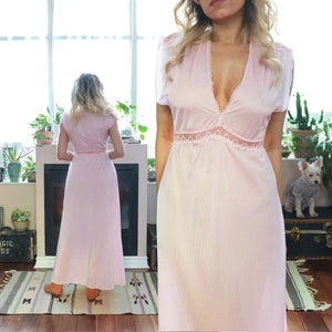 May include: A long, pink, sleeveless nightgown with a lace trim around the neckline and waist. The gown is made of a soft, silky fabric.