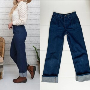 K&ouml;nnte beinhalten: Eine dunkelblaue Jeanshose mit hoher Taille und umgeschlagenem Saum. Die Jeans hat einen geraden Schnitt und ist aus Denim gefertigt.