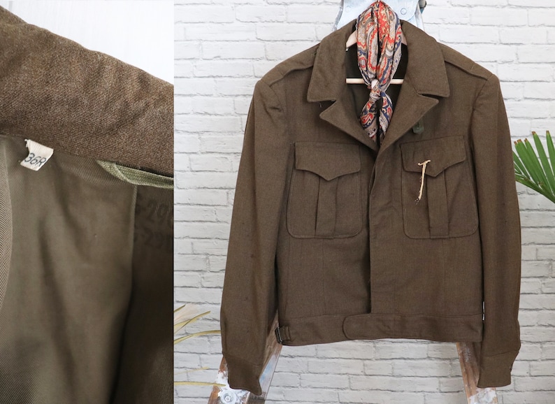 Pu&ograve; includere: Giacca marrone in stile militare con quattro tasche frontali e chiusura con bottoni. La giacca ha un colletto e un dettaglio in vita con cintura. Una sciarpa fantasia &egrave; appesa al colletto. La fodera interna &egrave; visibile.