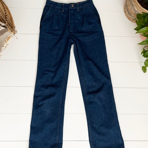 K&ouml;nnte beinhalten: Eine dunkelblaue, hochgeschnittene, weite Jeans mit Knopfleiste und Falten vorne.
