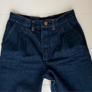 K&ouml;nnte beinhalten: Eine dunkelblaue Jeanshose mit Falten und einem Knopfverschluss.