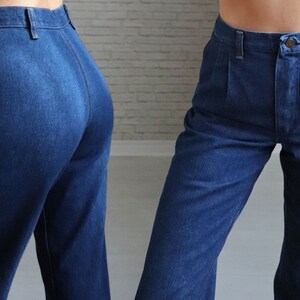 May include: A pair of high-waisted, blue denim jeans with a straight leg fit. The jeans have a button fly and belt loops.