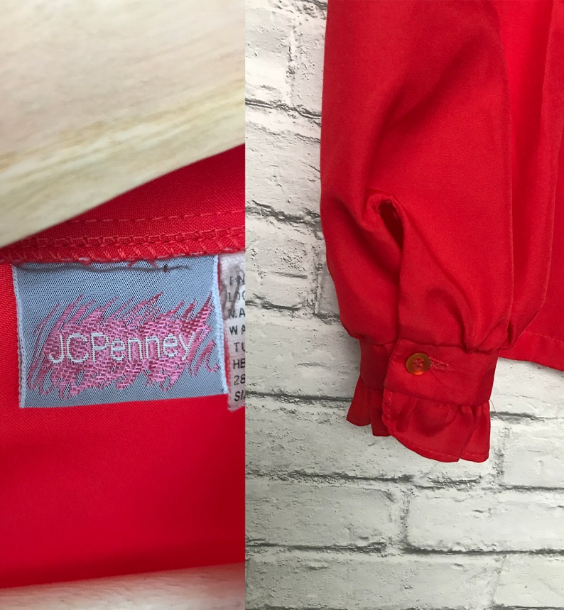 May include: A red long-sleeved blouse with a ruffled cuff and a JCPenney label. The blouse is made of a lightweight fabric.