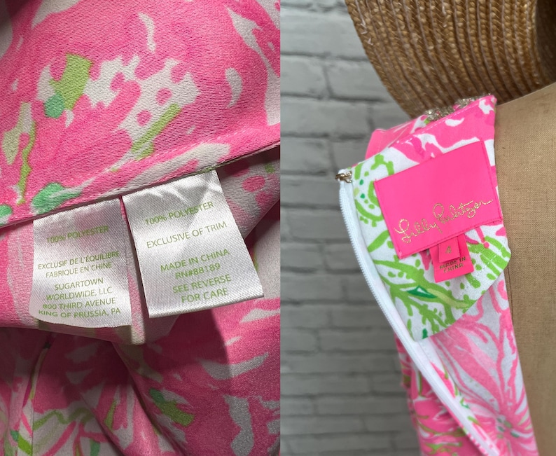 May include: A sleeveless dress featuring a vibrant pink, white, and green floral pattern. The interior includes a bright pink Lilly Pulitzer brand label and a white care tag stating 100% polyester, made in China, and Sugartown Worldwide, LLC.