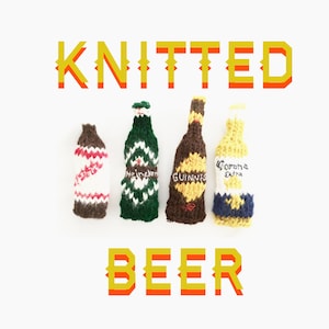 Peut inclure: Quatre housses de bouteilles de bière tricotées de différentes couleurs. L'une est blanche avec des rayures rouges, une autre verte avec des accents blancs, une marron avec des accents dorés et une jaune avec des accents bleus. Les mots "KNITTED" et "BEER" sont dans l'image.