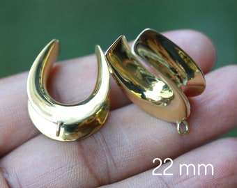 May include: A pair of gold-colored metal ear gauges, each with a curved, U-shaped design. The gauges are 22 mm in diameter.