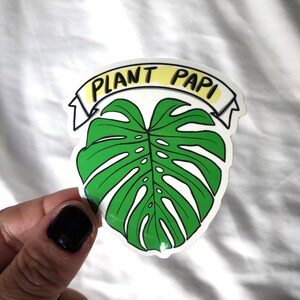 May include: A green monstera leaf sticker with a yellow banner that reads "Plant Papi".
