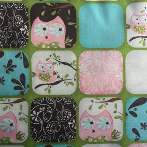May include: A colorful fabric with a repeating pattern of owls and floral designs. The fabric features a variety of colors, including pink, blue, green, and black.
