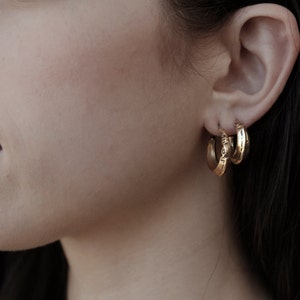 Gold engraved stacking hoop earrings with a sterling silver ear post