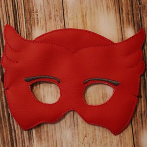 May include: Red felt superhero mask with gray eye holes and stitched details. The mask has two small wings on the top.