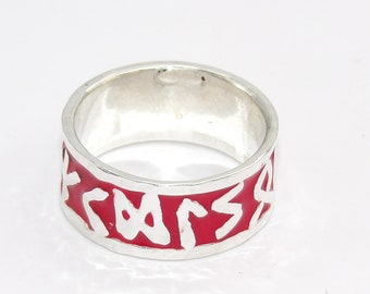 Puede incluir: Un anillo de plata con una banda de esmalte rojo y una inscripción blanca.