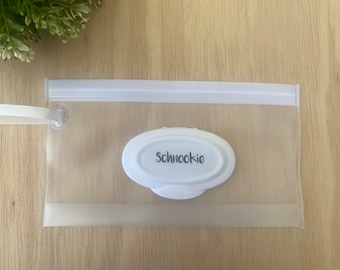 Puede incluir: Una bolsa de plástico transparente con cremallera, con una cremallera blanca y una etiqueta ovalada blanca que dice "Schnookie".