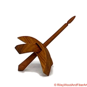 May include: A wooden spinning wheel with a curved base and a spindle. The wheel is made of light brown wood and the spindle is made of dark brown wood.