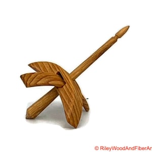 May include: A wooden spinning wheel with a spindle and a base. The wheel is made of light brown wood and has a natural finish.