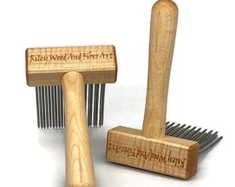 May include: Two wooden fiber art tools with handles and metal tines. The tools are light-colored wood with the text "Riley Wood And Fiber Art" engraved on the top. The tools are used for fiber art.