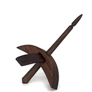 May include: A dark brown wooden drop spindle with a pointed tip and a curved base. The spindle is made of a single piece of wood and has a smooth finish.
