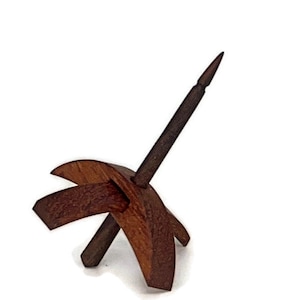 May include: A wooden spinning wheel with a dark brown finish. The wheel has a single spindle and a base with two arms.