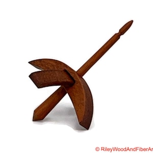 May include: A wooden spinning wheel with a brown finish. The wheel is shaped like a crescent moon and has a spindle that extends out from the centre.