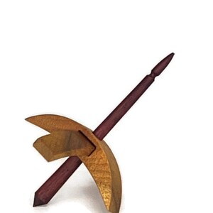 May include: A wooden spinning wheel with a dark red spindle and a light brown, curved whorl.