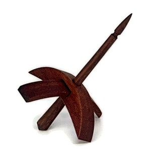 May include: A wooden spinning wheel with a dark brown finish. The wheel has a spindle that is attached to a base with two curved arms.